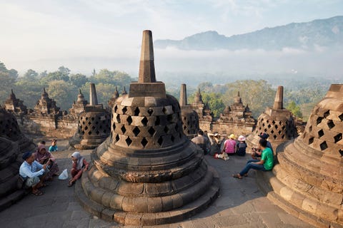 Boroboedoer IndonesiHet tempelcomplex Boroboedoer in MiddenJava is de grootste boeddhistische tempel ter wereld Er zijn 3000 basrelifbeeldhouwwerken 72 opengewerkte stoepas en 504 Boeddhabeelden Deze staan allemaal opgesteld in de vorm van een lotus Op de achtergrond zie je het Menorehgebergte De klim vanaf de oostelijke trap van Boroboedoer tot aan de laatste stoepa beslaat negen terrassen en bijna vier kilometer