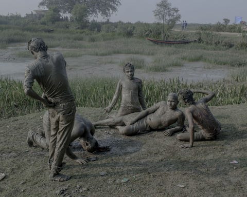Aangeschoten picnickers baden in modder langs de Ganges op Nieuwjaarsdag Modderbaden worden beschouwd als therapeutisch maar de modder langs de Ganges is vaak vervuild