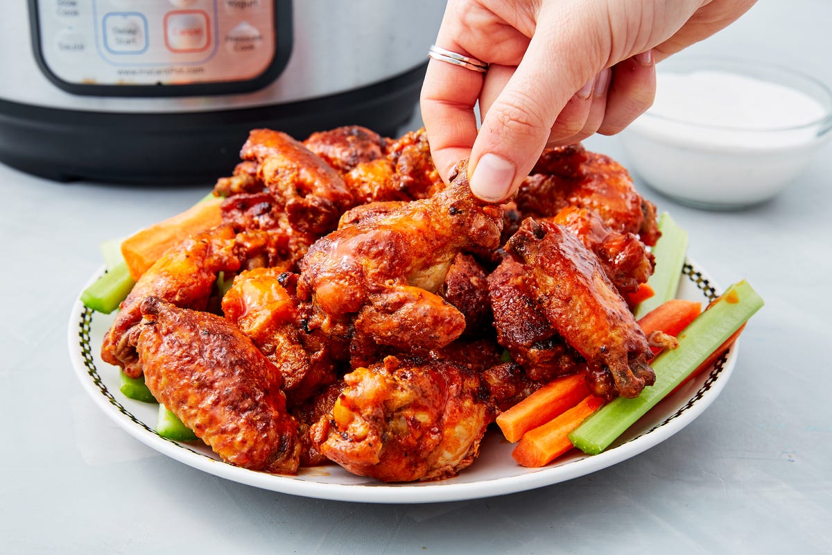 a pile of crispy instant pot chicken wings on top of crudite