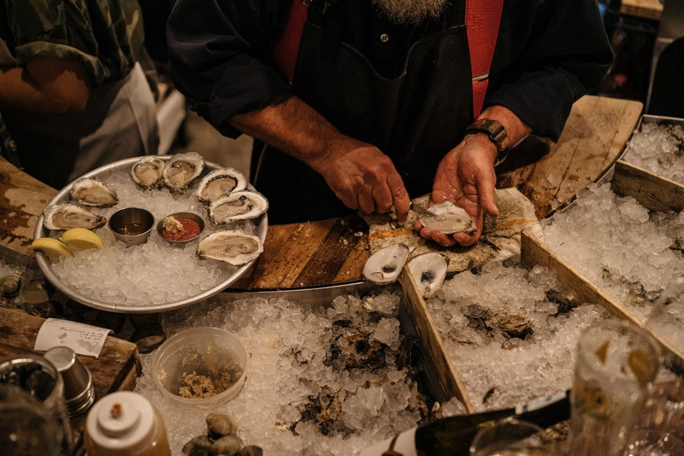 In Dylans Oyster Cellar in Baltimore Maryland worden oesters in hun schelp voor de gasten bereid In de vroege twintigste eeuw was Baltimore een van de grootste oesterproducenten van de VS maar decennia van overbevissing ziekten en vervuiling richtten de oestervisserij bijna te gronde