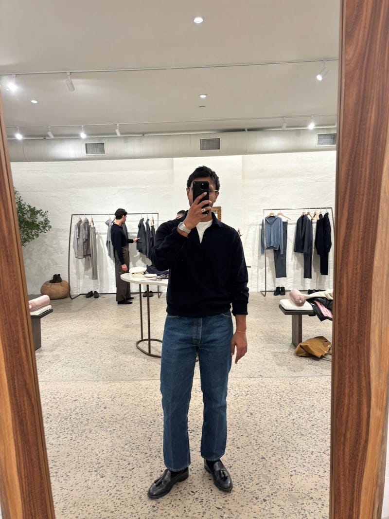 mirrored reflection of a person in a clothing store