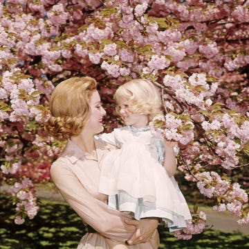1950s 1960s REDHEAD MOTHER... 1950s 1960s redhead mother holding blonde girl daughter among cherry tree blossoms (photo by h. armstrong roberts/classicstock/getty images)