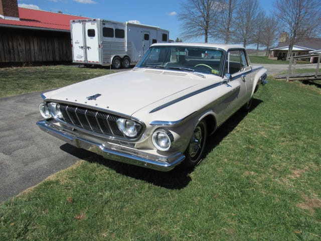 front three quarter view of a white 1962 dodge polara 500, highlighting the grille, headlights, and chrome bumper.