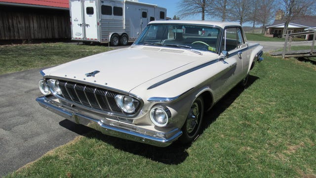 1962 Dodge Polara front three quarter view of a white 1962 dodge polara 500, highlighting the grille, headlights, and chrome bumper.