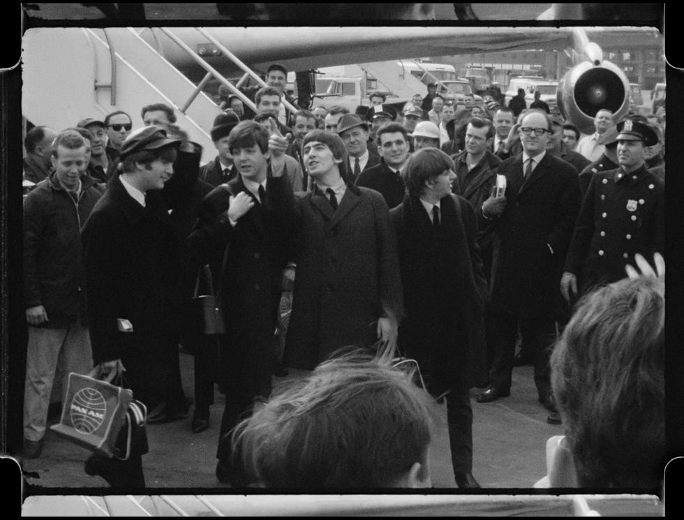 crowd at a transport hub with notable individuals in formal attire