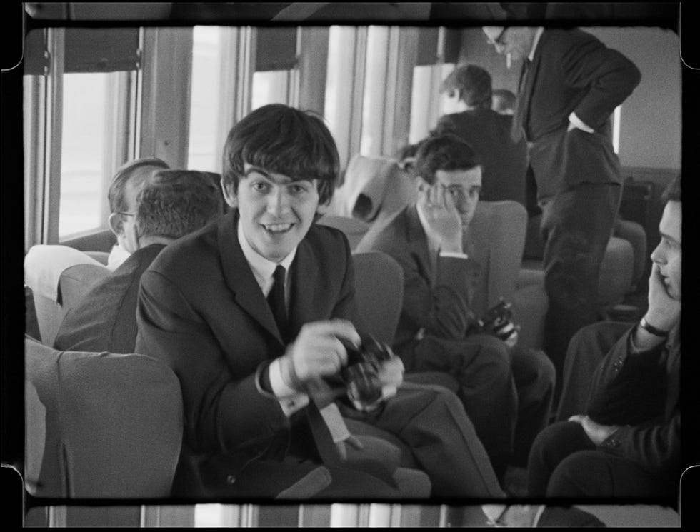 guests sitting in a train carriage some interacting while others appear contemplative