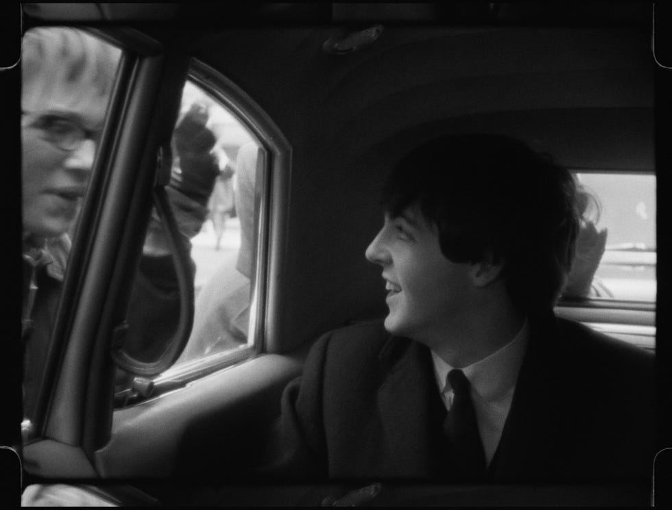 person sitting inside a car looking out the window