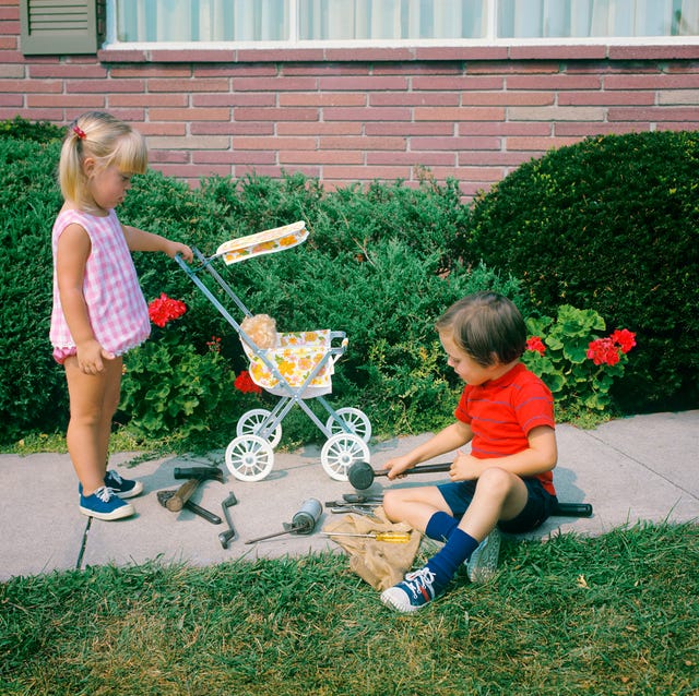 1970s LITTLE GIRL PUSHING... 1970s little girl pushing toy baby carriage and boy playing with tools on sidewalk gender specific role play (photo by h. armstrong roberts/classicstock/getty images)