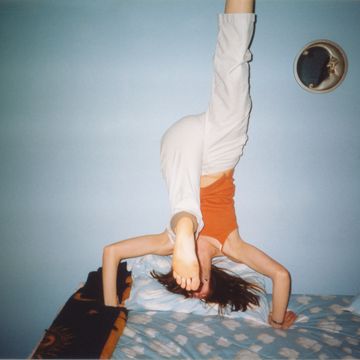 1990s teenager having fun, young girl doing headstand