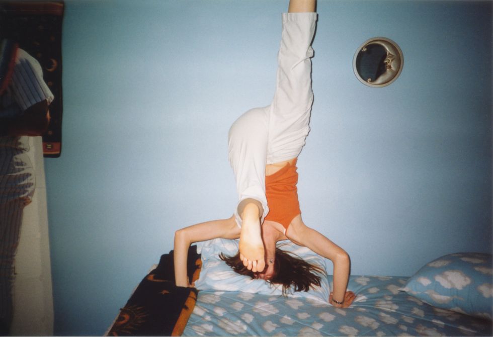 1990s teenager having fun, young girl doing headstand