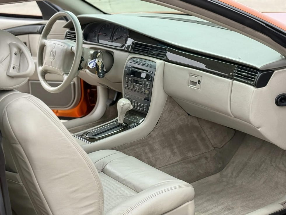 interior of a 1999 cadillac eldorado concept car, featuring beige leather seats, dashboard controls, and a steering wheel with cadillac branding.