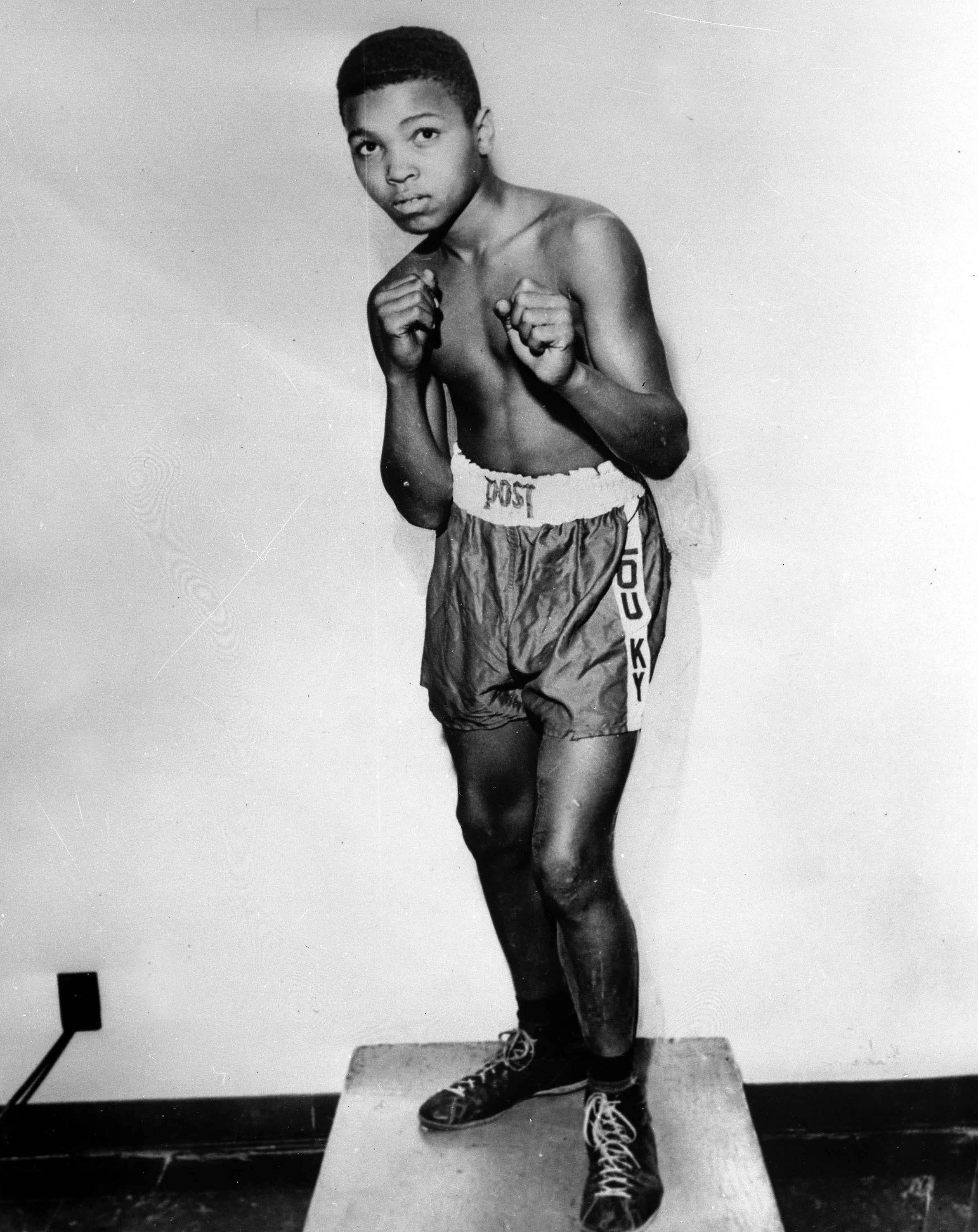 muhammad ali in childhood wearing boxing trunks and in a fighting stance