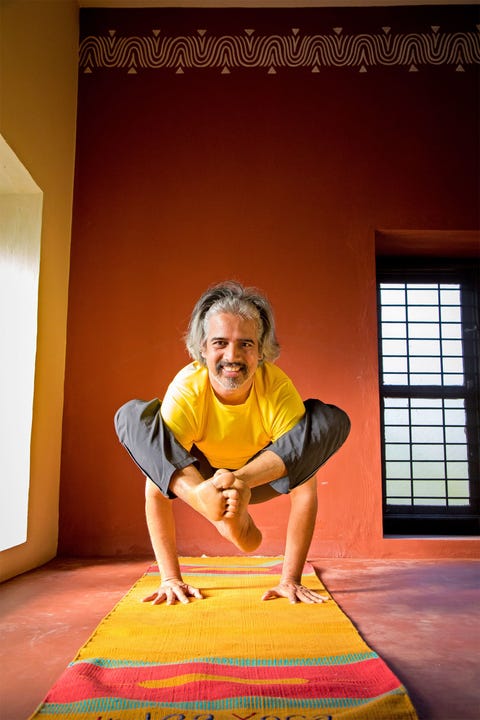 Yogaleraar Bharath Shetty in de kraanvogelhouding Bakasana in zijn studio in Mysore