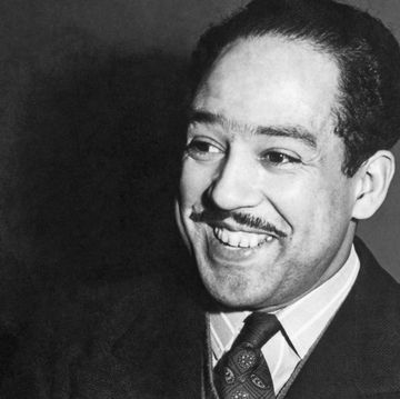 black and white photo of langston hughes smiling past the foreground