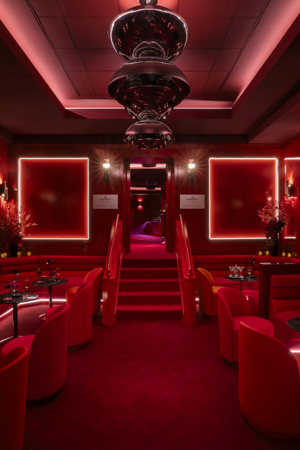 Vibrant interior of a luxurious lounge with red decor and modern lighting.