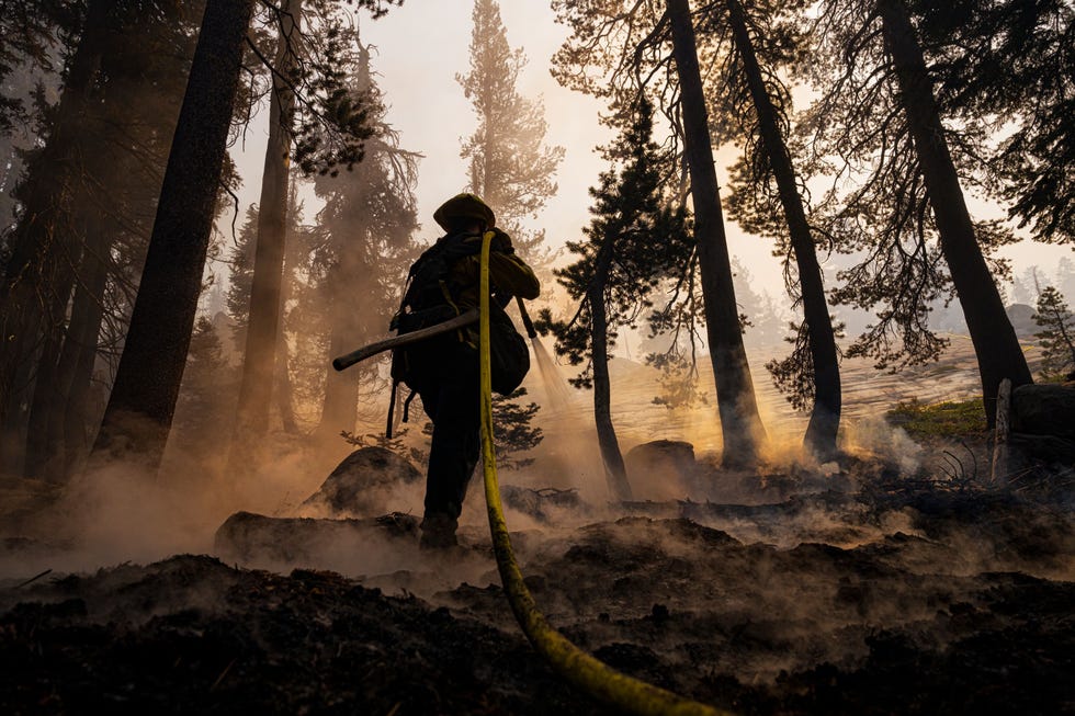 In haar tweede seizoen bij CAL FIRE dooft Heather Kirkendall 27 uit San Mateo Californi hotspots in de rook van het Caldor Fire dat nog nasmeult in de buurt van de Carson Pas nabij het Kirkwood Mountain Resort in Californi 1 september 2021