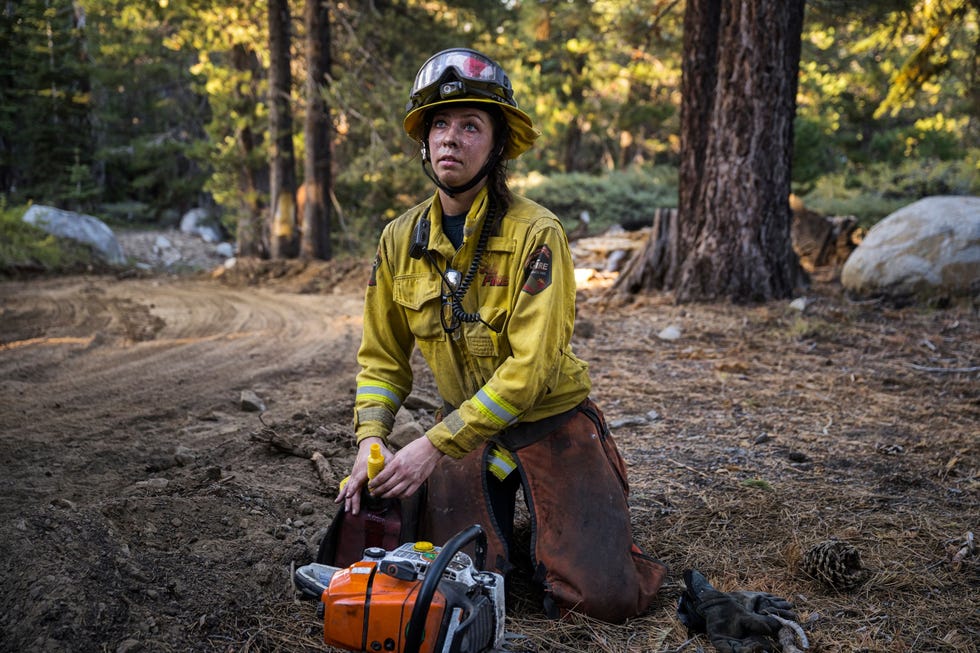 Chainsaw refuel Kirkendall vult een kettingzaag met benzine terwijl ze bezig is met het weghalen van vegetatie rond de boshutten op de Carson Pass in Californi 1 september 2021