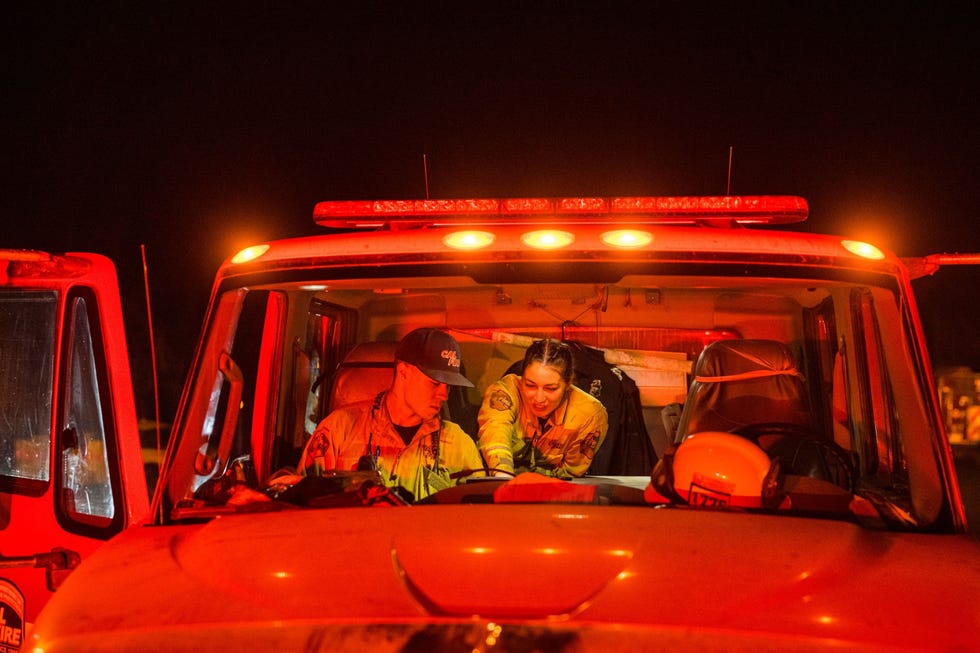 Engine Cab Brandweerlieden Meglan Enz 26 rechts uit Hollister Californi en Mateo Corona 20 uit Ben Lomand Californi werken bij de eenheid San MateoSan Cruz van CAL FIRE Hier kijken ze naar een scherm in afwachting van nadere instructies voor de potentieel nachtelijke brandbestrijding op de Carson Pass in Californi 4 september 2021 Enz is bezig aan haar derde seizoen bij CAL FIRE en zegt Ik ben dol op dit werk maar ik wil er niet mee getrouwd zijn Ik wil buiten het brandweerwerk een normaal leven hebben ook al is het lastig om beide te combineren Maar ik denk dat het te doen is