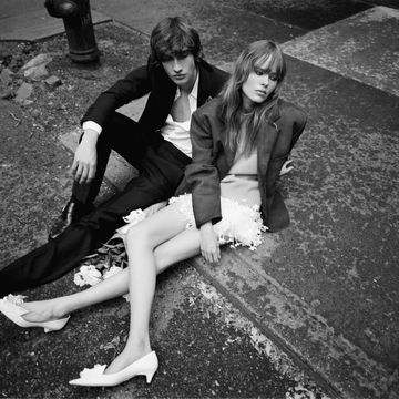a man and woman sitting on a curb