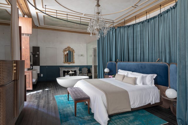 Luxury bedroom with a contemporary design, featuring a bed and a freestanding bathtub.