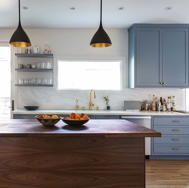 kitchen with center block, blue cabinets, white walls, black and gold pendant lights