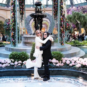 a bride in a white suit and a bride in a black suit pose at the bellagio in las vegas