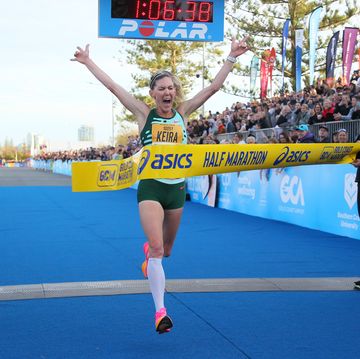 kiera damato joyfully breaks the finish line tape at the 2023 gold coast half marathon