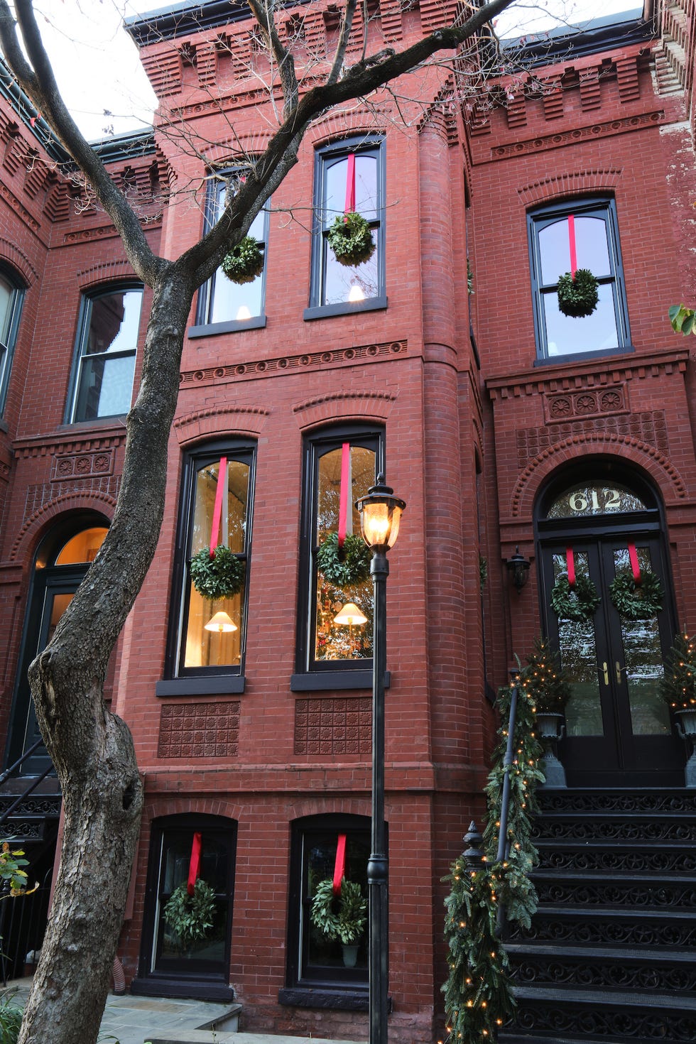Josh Young DC Townhouse josh young townhouse in dc with wreaths bedecking every window across all three floors, as well as the glass front doors