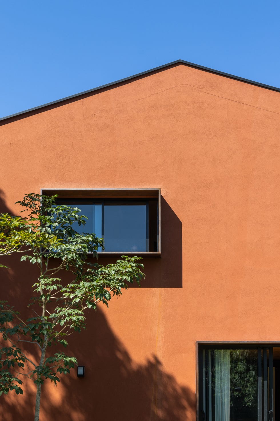 casa roja de los 90 de vivienda convencional de espacio pequeños a abrirse al paisaje