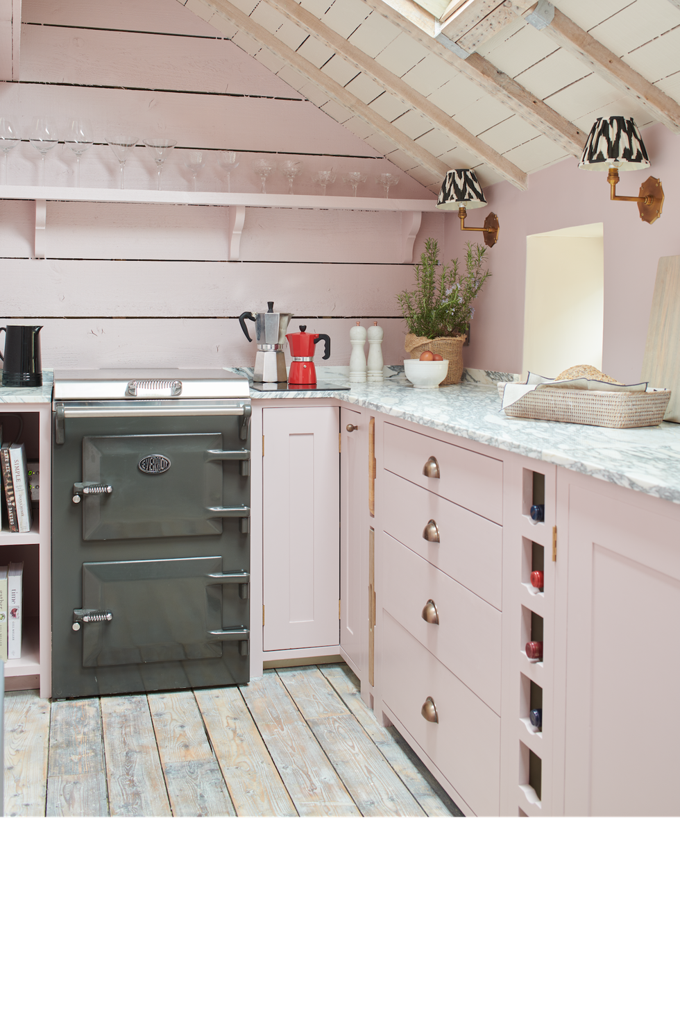 a small pastel pink kitchen with open shelving