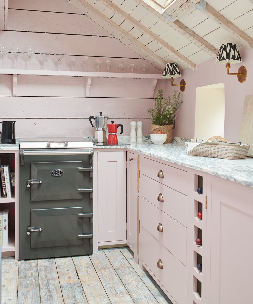 a small pastel pink kitchen with open shelving