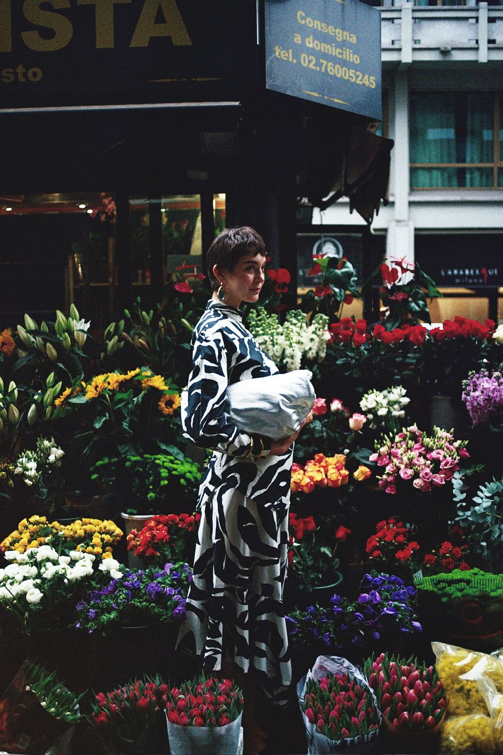 a person standing in front of a flower shop