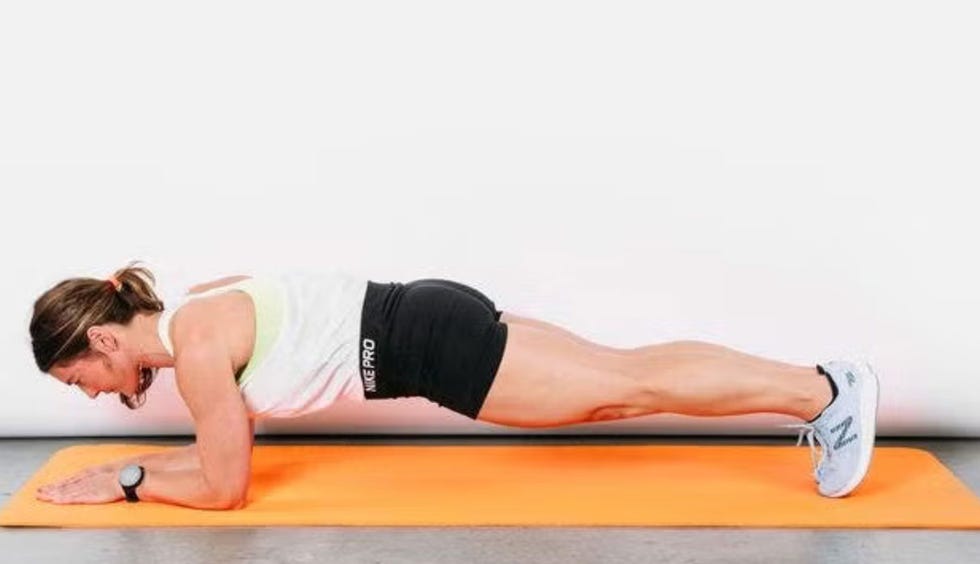 individual performing a plank exercise on an orange mat