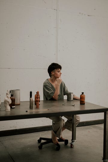 la artesana silvia duran en una mesa posando con sus velas artesanales de colores