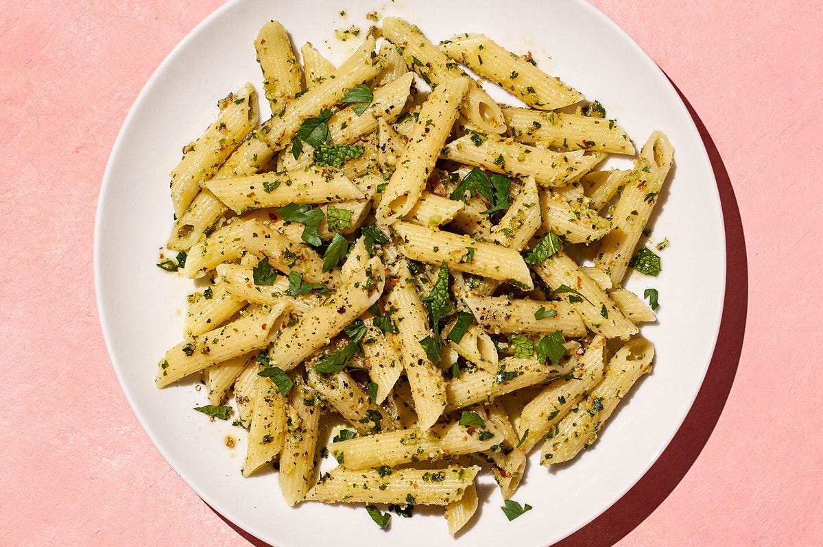 pasta with herbs on a pink background