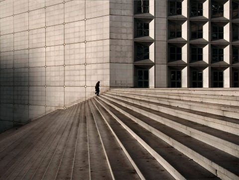 Een persoon loopt door La Grande Arche de la Dfense het monument dat bedoeld is als venster op de wereld La Grande Arche is ruim 30000 ton zwaar voor de bouw was 125000 kubieke meter beton nodig