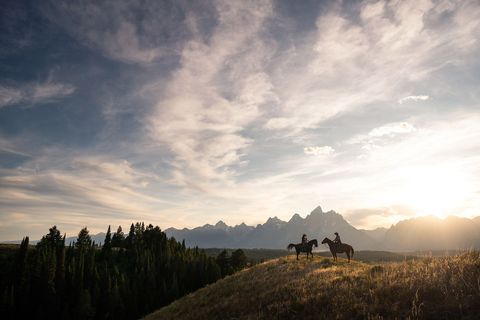 GRAND TETON NATIONAL PARK WYOMING VS  Twee ruiters pauzeren bovenop een heuvelkam aan de westrand van het Grand Teton National Park De scherpe door breuklijnen en gletsjers gebeeldhouwde pieken van de Tetons die veelal tot boven de 3600 meter verrijzen vormen een adembenemend onderdeel van de Centrale Rocky Mountains