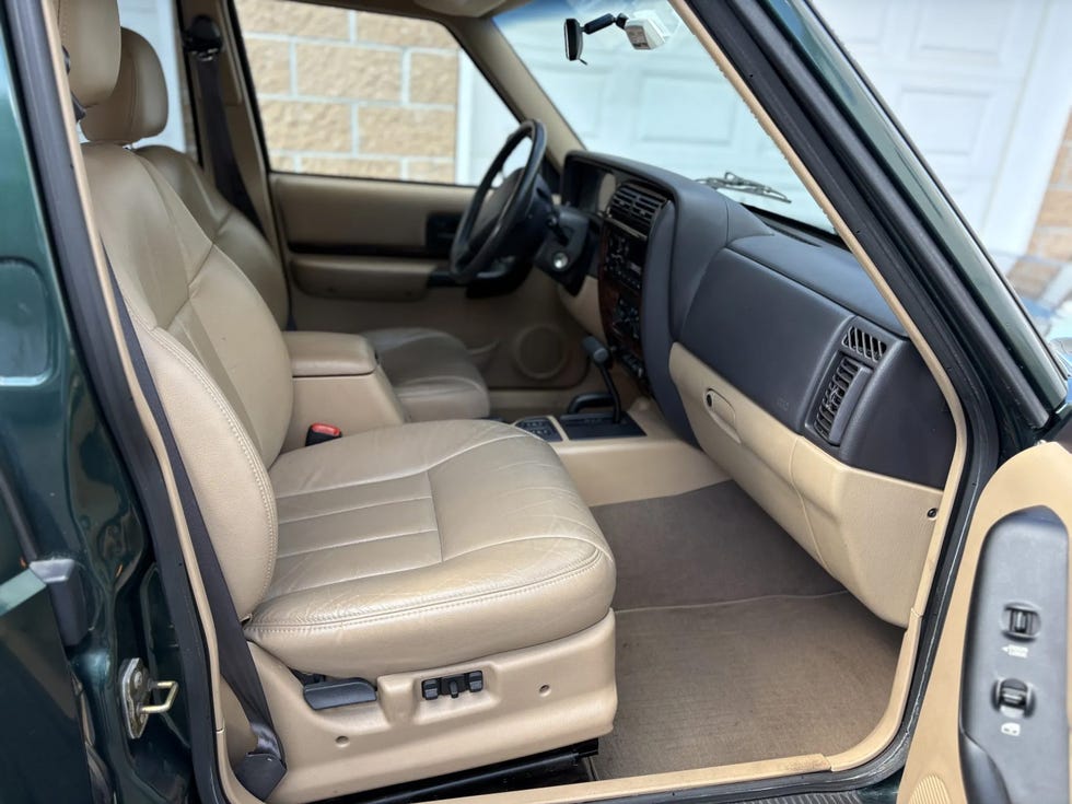 interior view of a jeep cherokee with tan leather seats, a black dashboard, and a center console.
