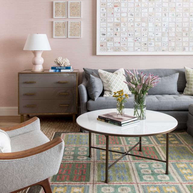 pink wallpaper, gray sofa, circular coffee table, wall art