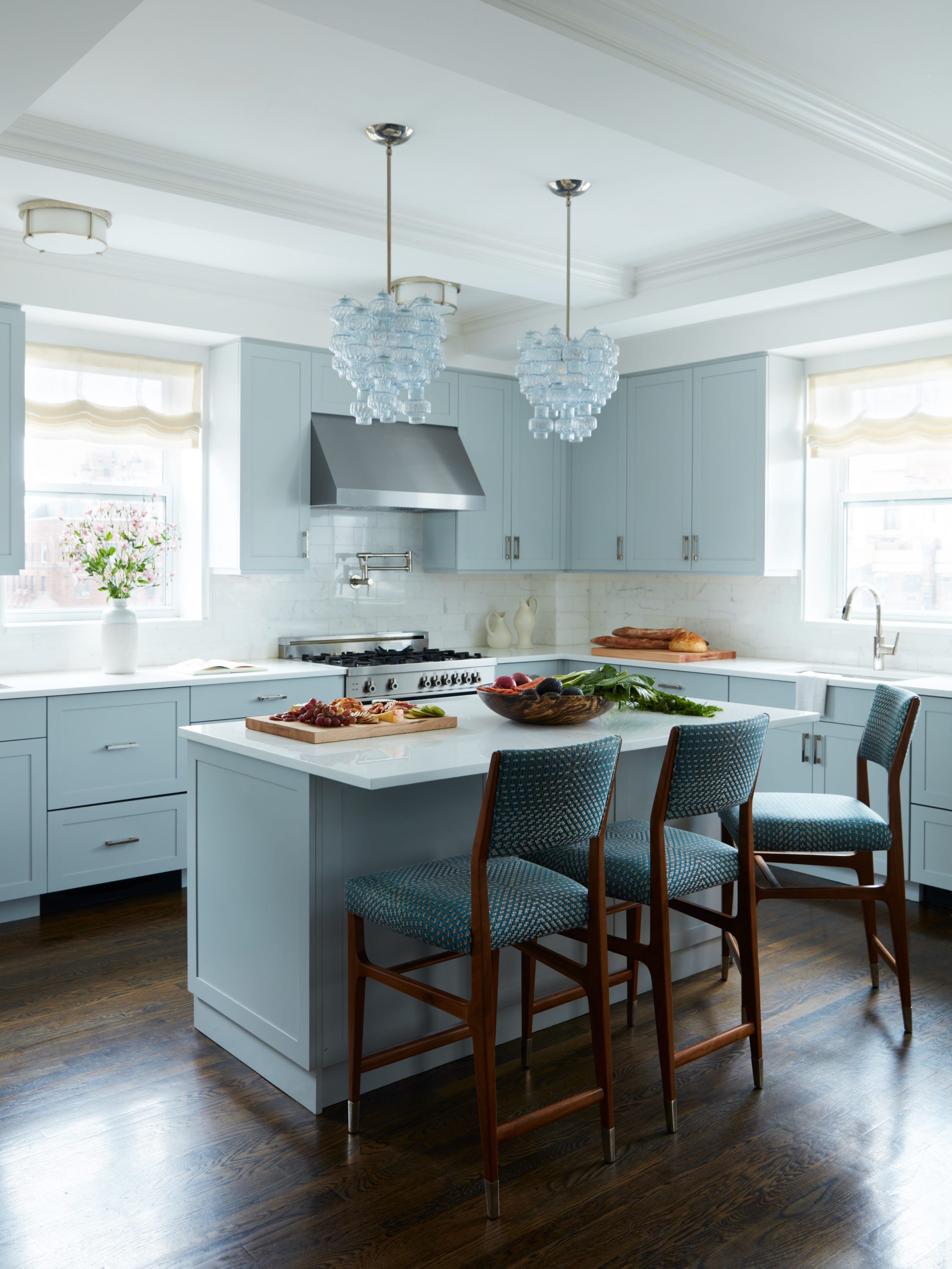 cocina con isla en azul claro con suelos de madera oscura