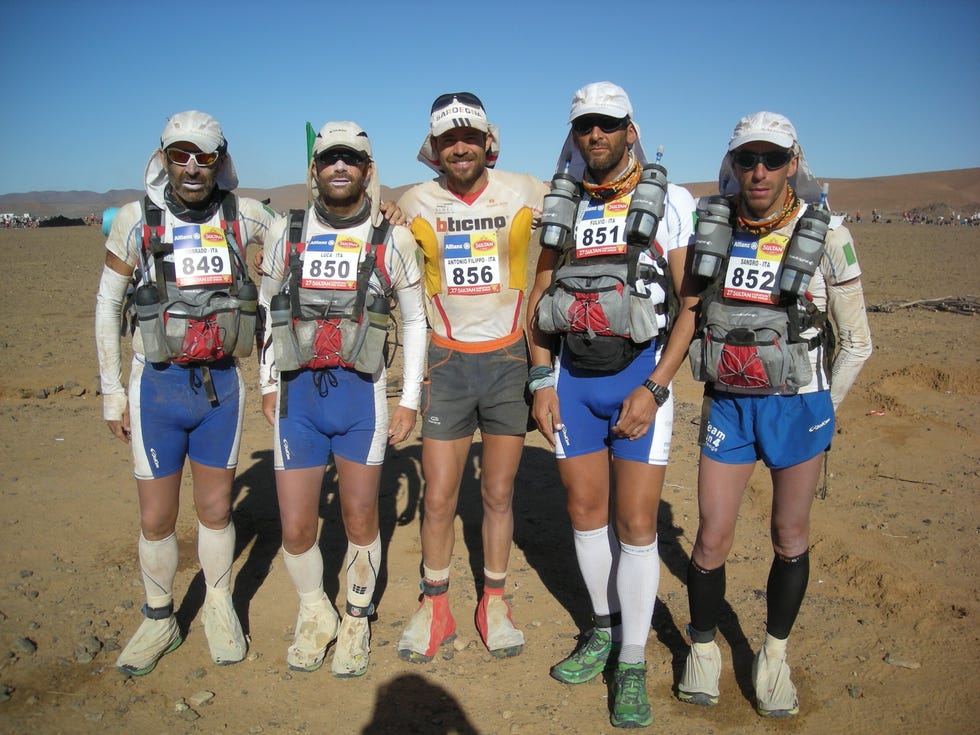a group of people wearing helmets and standing on a dirt hill