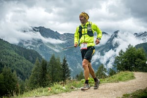 a man running on a trail in the mountains