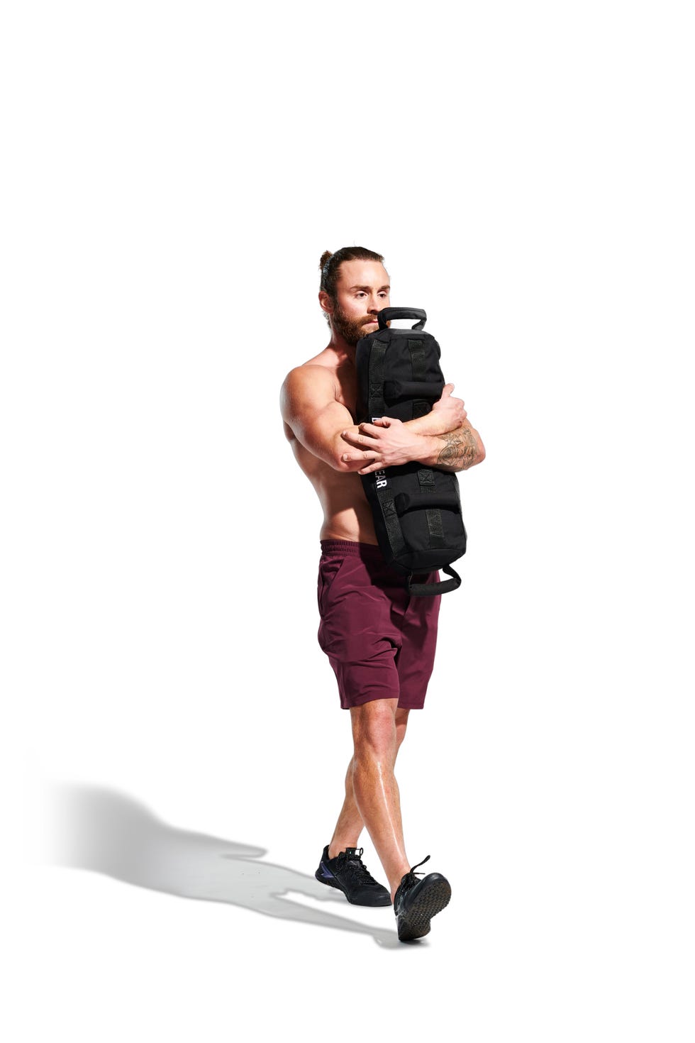 a male model, wearing burgundy shorts and black trainers demonstrating different excercises