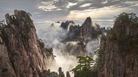 BERGKETEN HUANGSHAN, CHINA BERGKETEN HUANGSHAN CHINAHuangshan wat Gele Berg betekent is een bergketen in het zuiden van de provincie Anhui in OostChina Het gebied staat bekend om zijn prachtige landschappen zonsondergangen grillige granietpieken Huangshandennen hete bronnen wintersneeuw en spectaculair laaghangende wolken Huangshan is een geliefd onderwerp in de traditionele Chinese schilderkunst en literatuur en in de moderne fotografie Het een UNESCOWerelderfgoed en een van de belangrijkste toeristische bestemmingen van China