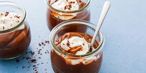 chocolate pudding in glass jars with whipped cream and chocolate shavings
