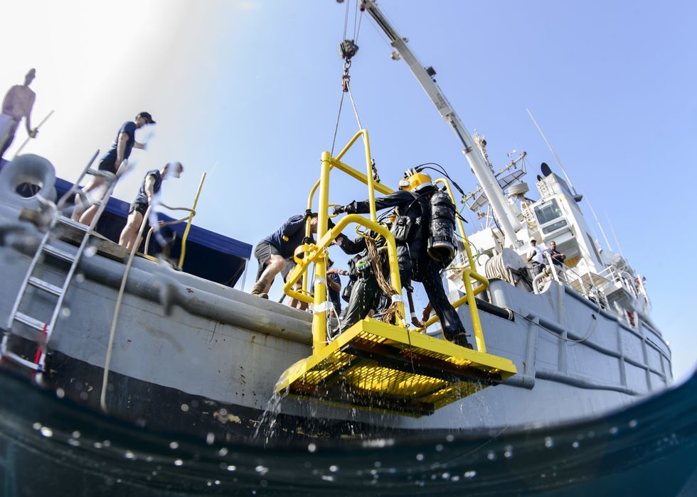 150527 n qa919 195 arabian gulf may 27, 2015 divers assigned to commander, task group ctg 561, hoist a diving stage over the side of the fleet ocean tug usns catawba t atf 168 the divers are working to recover and salvage an aircraft lost at sea us navy photo by mass communication specialist 3rd class tyler n thompsonreleased