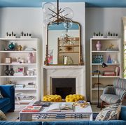 fireplace, blue ceiling, blue sofa, mirror, yellow stool