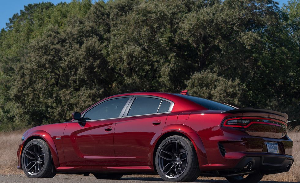2023 red dodge charger scat pack widebody parked alongside the highway