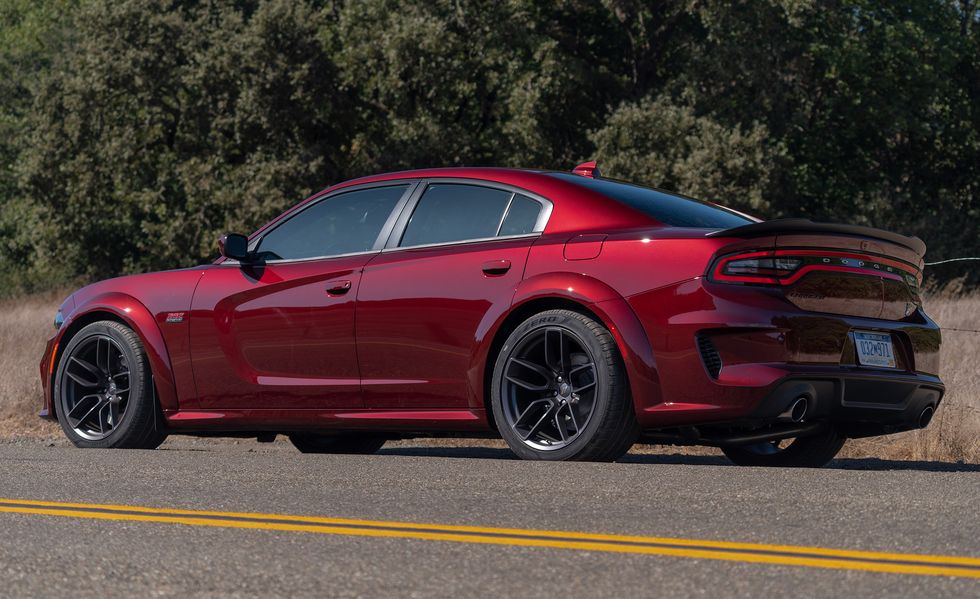 2023 red dodge charger scat pack widebody parked alongside the highway