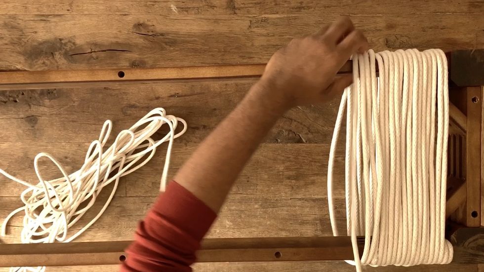 hand wrapping rope around wood